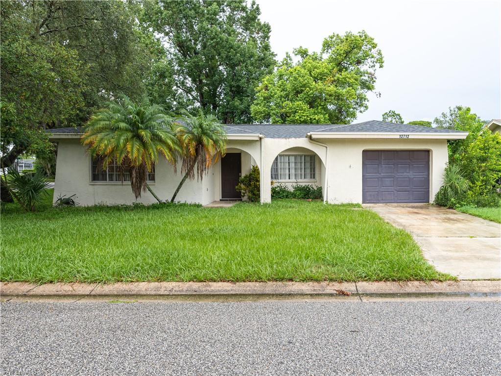 a front view of a house with a garden and yard