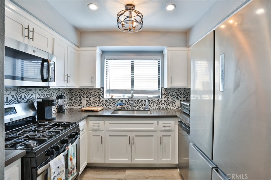 a kitchen with stainless steel appliances granite countertop a stove a sink and a refrigerator