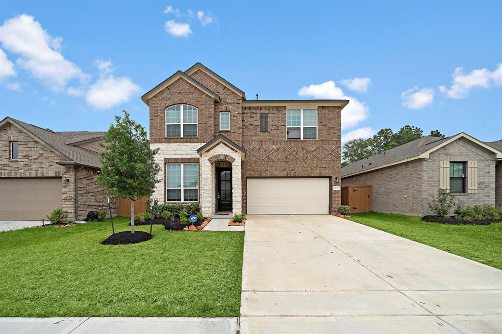 a front view of a house with a yard and garage