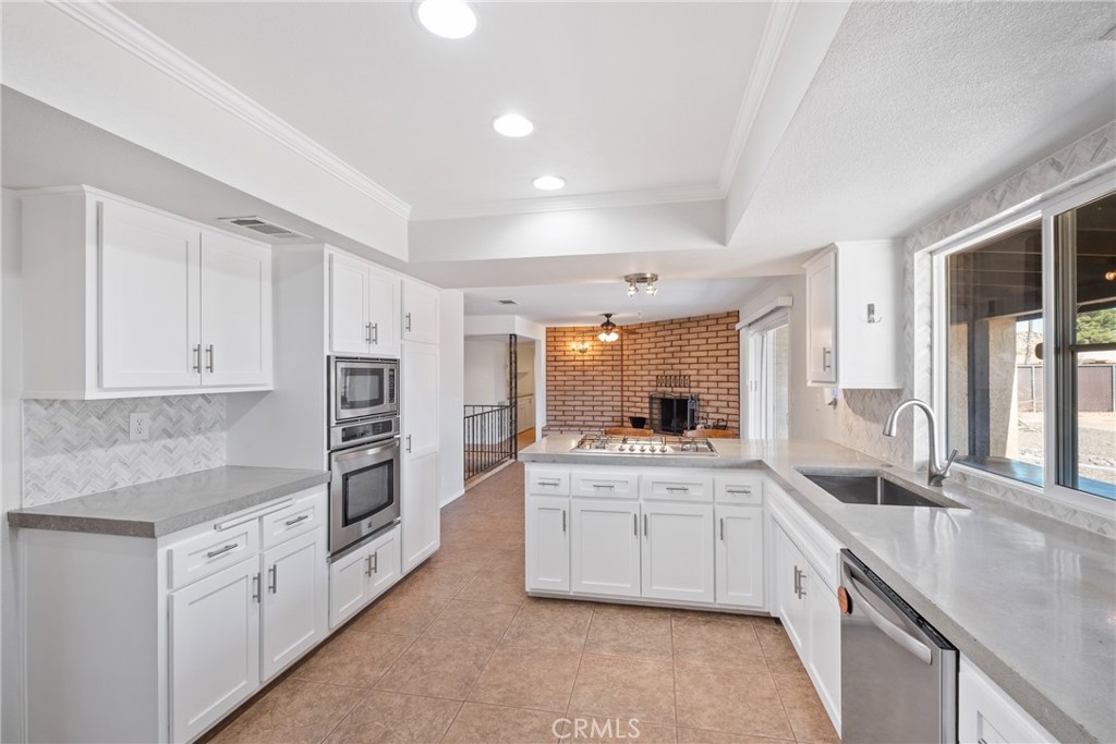 a kitchen with granite countertop a sink stove and cabinets