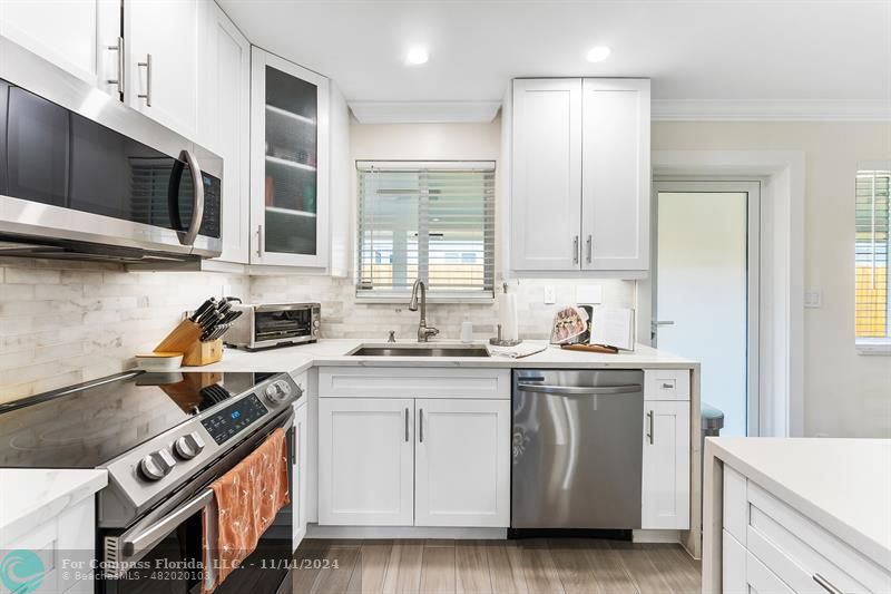 a kitchen with stainless steel appliances granite countertop a stove a sink and a microwave