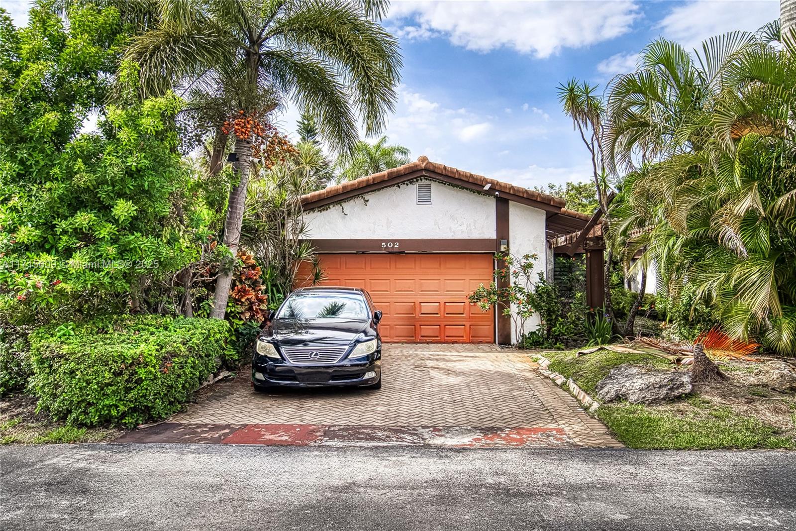 a car parked in front of a house with a small yard