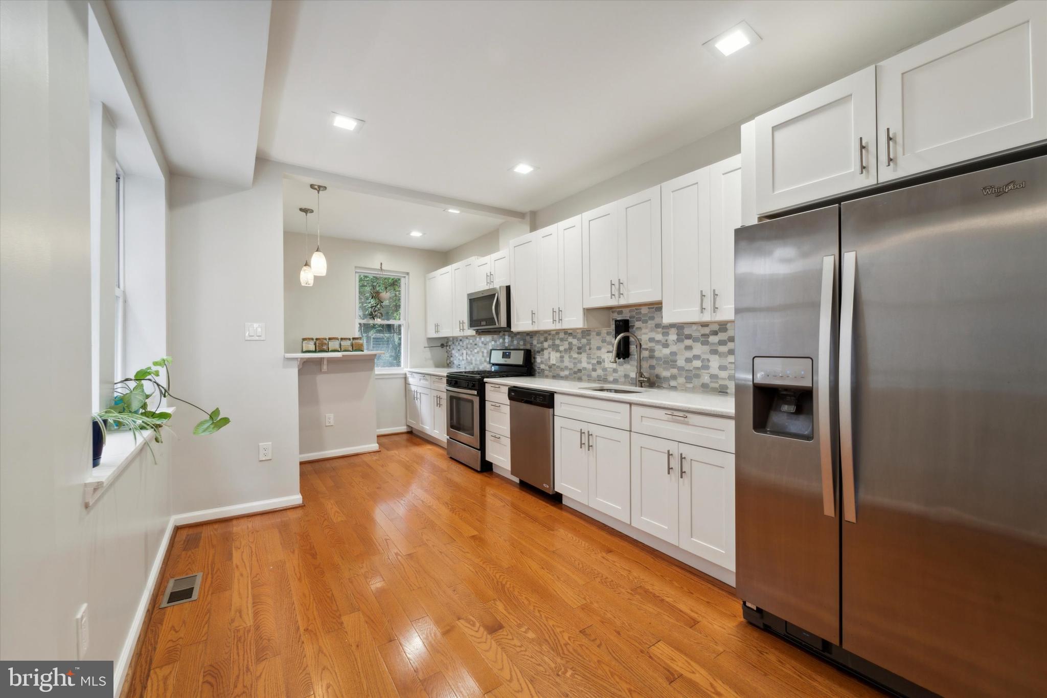 a kitchen with granite countertop stainless steel appliances and refrigerator