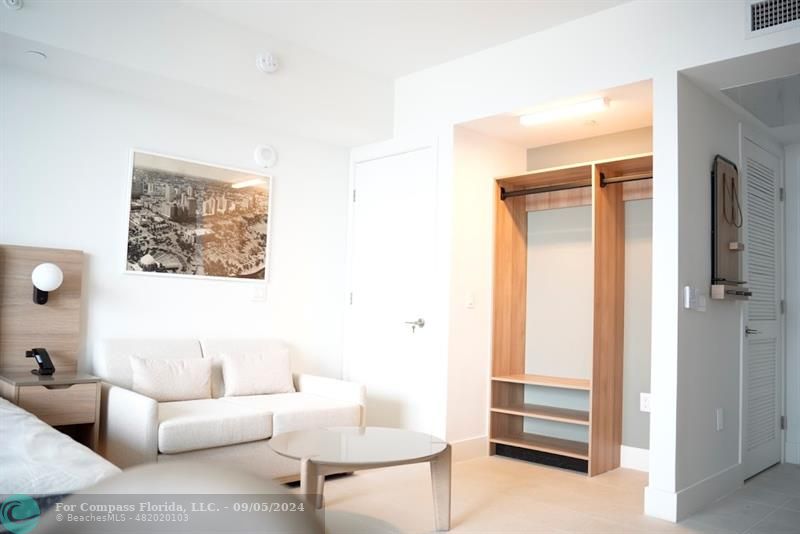 a living room with furniture and a painting on the wall