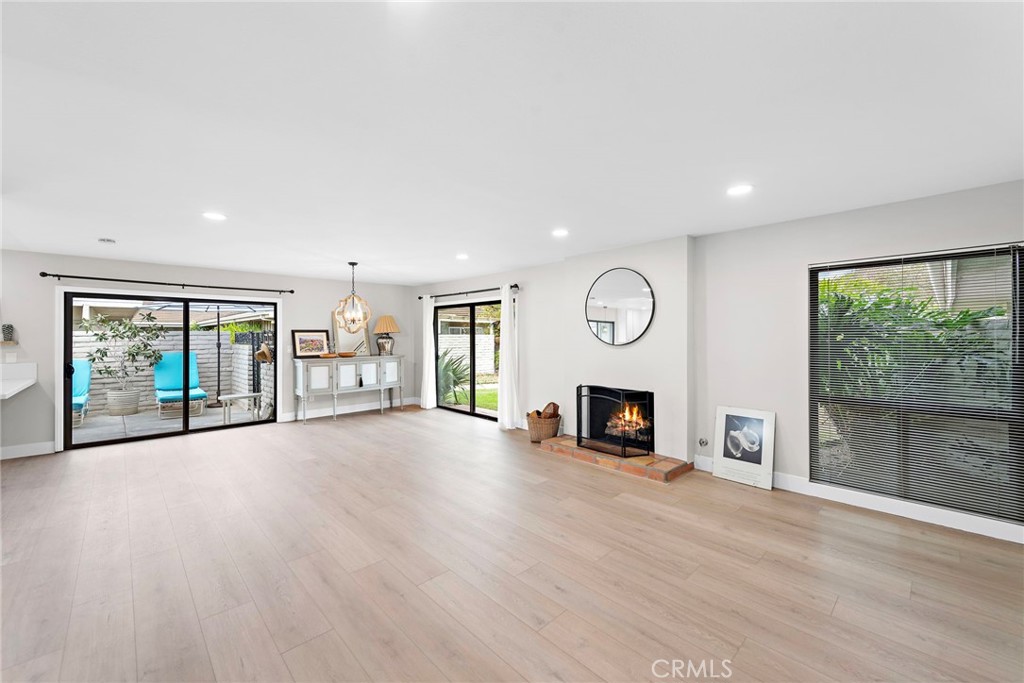 an empty room with fireplace fan and windows