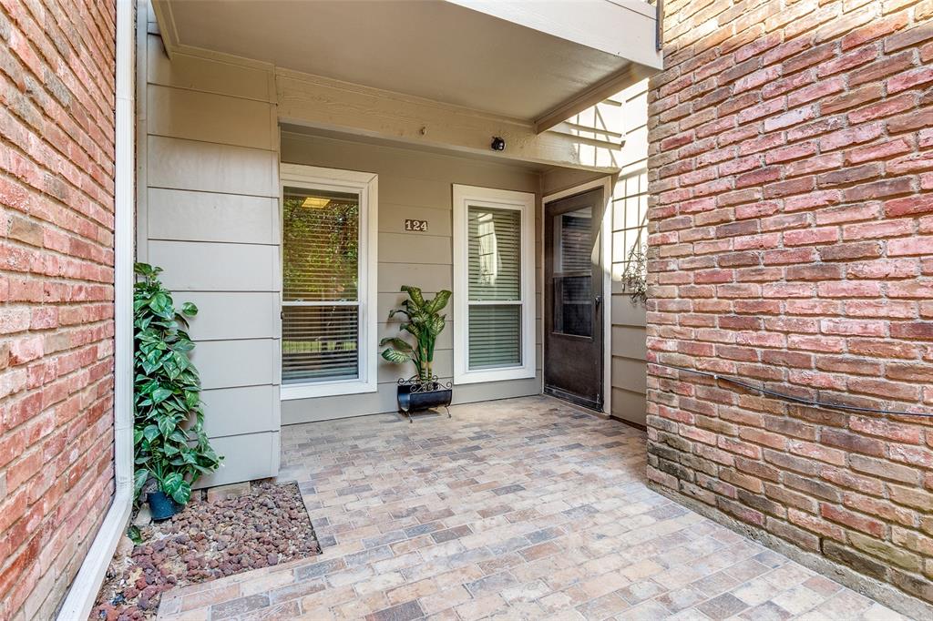 a view of a brick house with potted plants in front of door