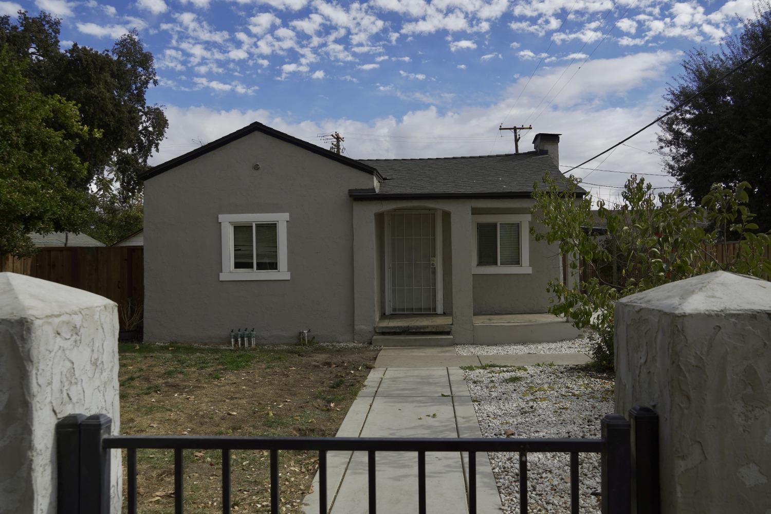 a view of house with backyard and trees