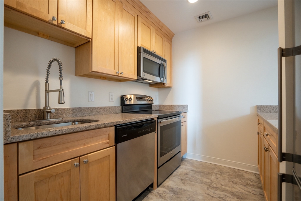 a kitchen with stainless steel appliances granite countertop a sink stove and microwave