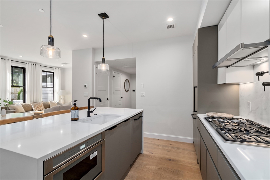 a kitchen with sink stove and cabinets