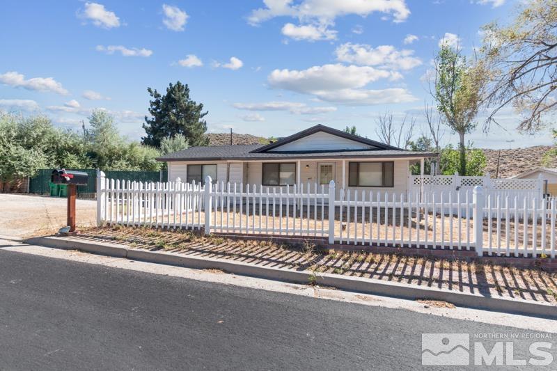 a view of a house with a small yard and wooden fence