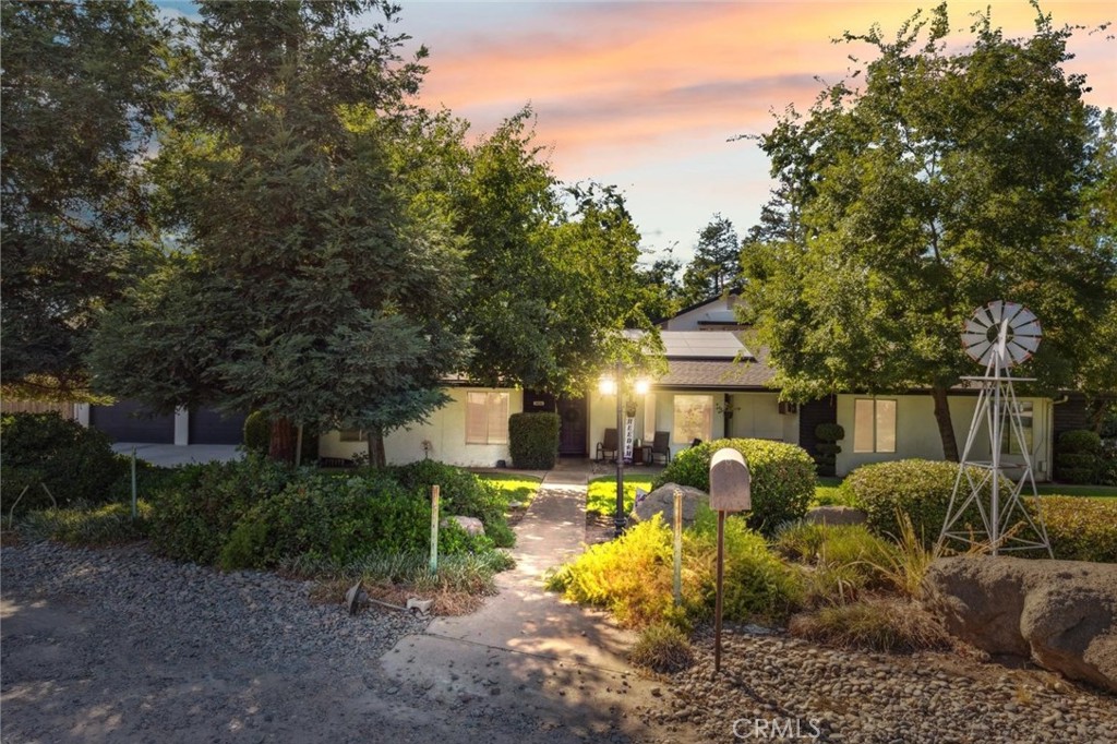 a view of a house with backyard outdoor seating area and trees