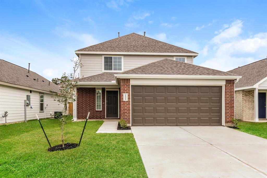 a front view of a house with a yard and garage