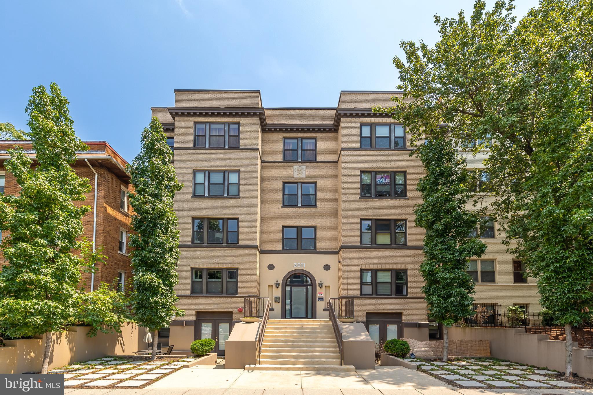 a front view of a multi story building with yard