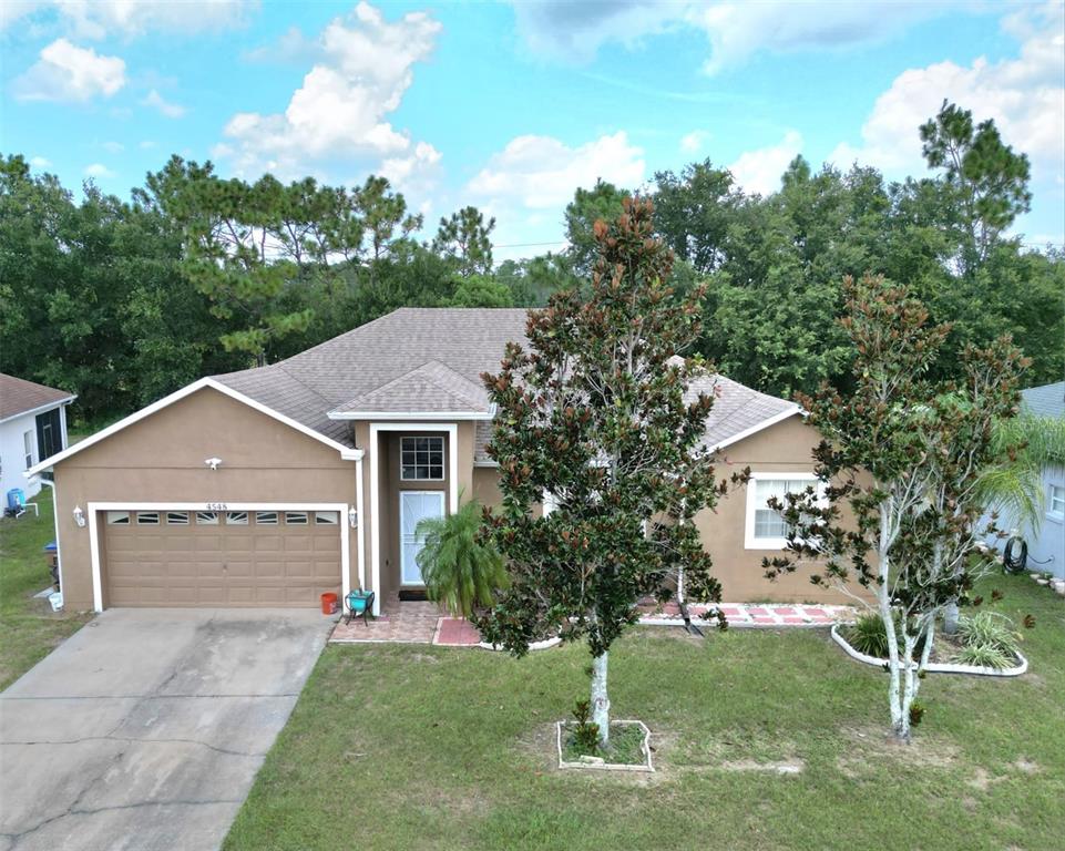 a front view of a house with a yard garage and trees