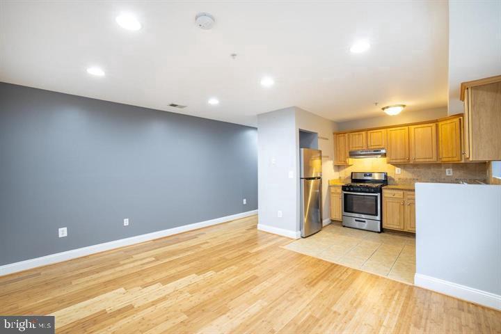 a kitchen with stainless steel appliances a refrigerator and a stove top oven