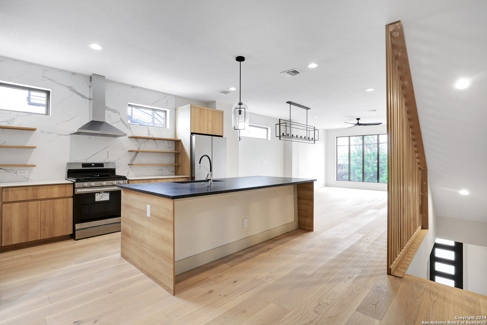 a kitchen with stainless steel appliances granite countertop a sink a stove and a refrigerator