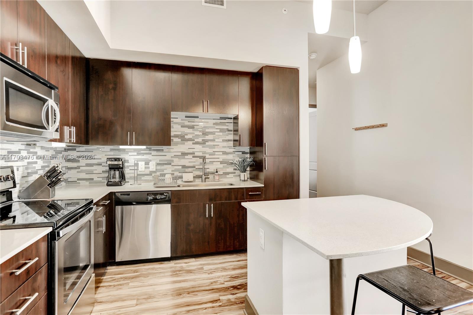 a kitchen with stainless steel appliances a sink cabinets and wooden floor