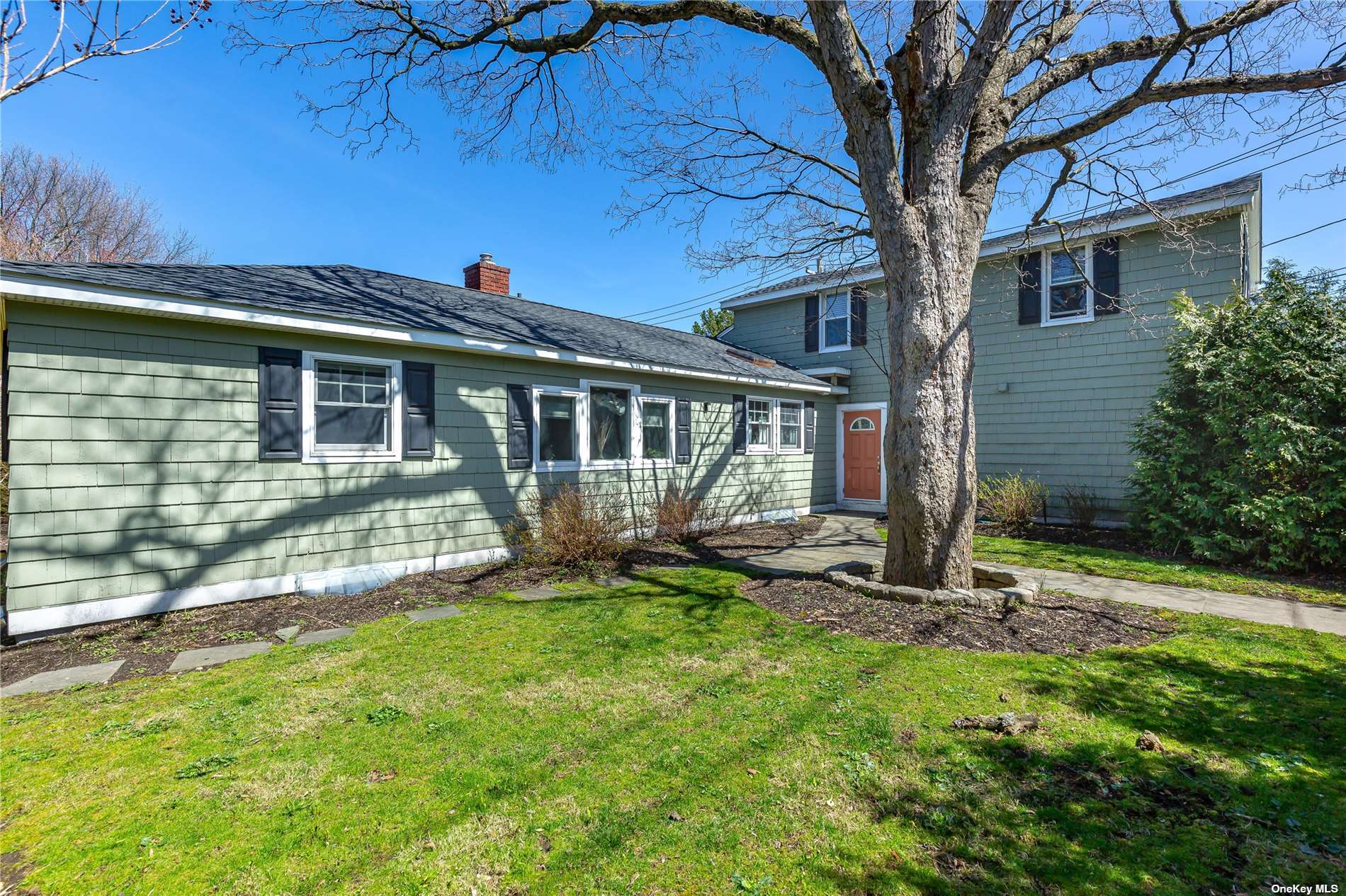 a view of a house with backyard and a tree