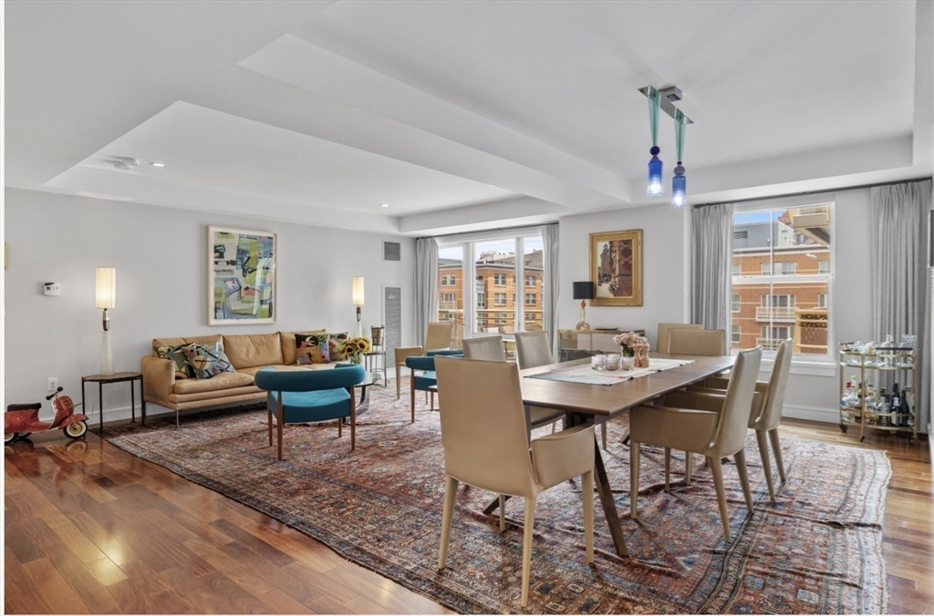 a dining room with furniture a chandelier and wooden floor