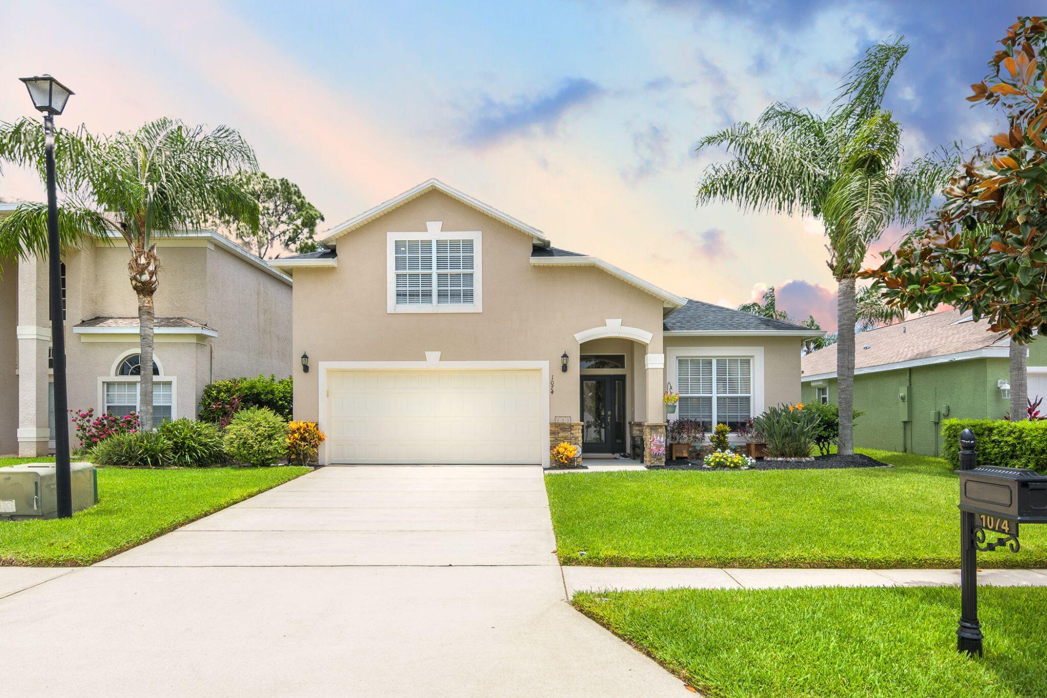 a front view of a house with a yard and trees