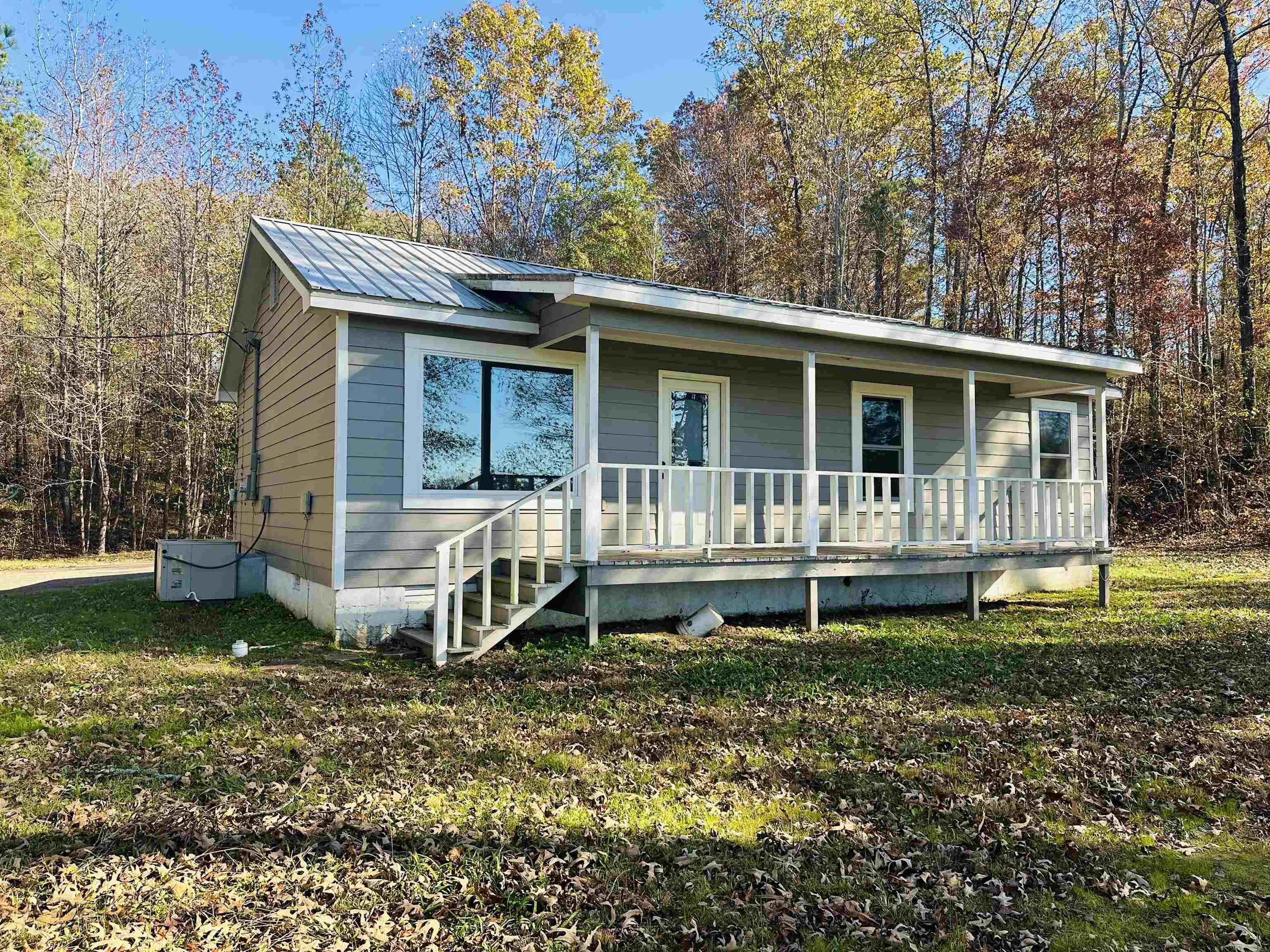 View of front of house with covered porch and a front yard