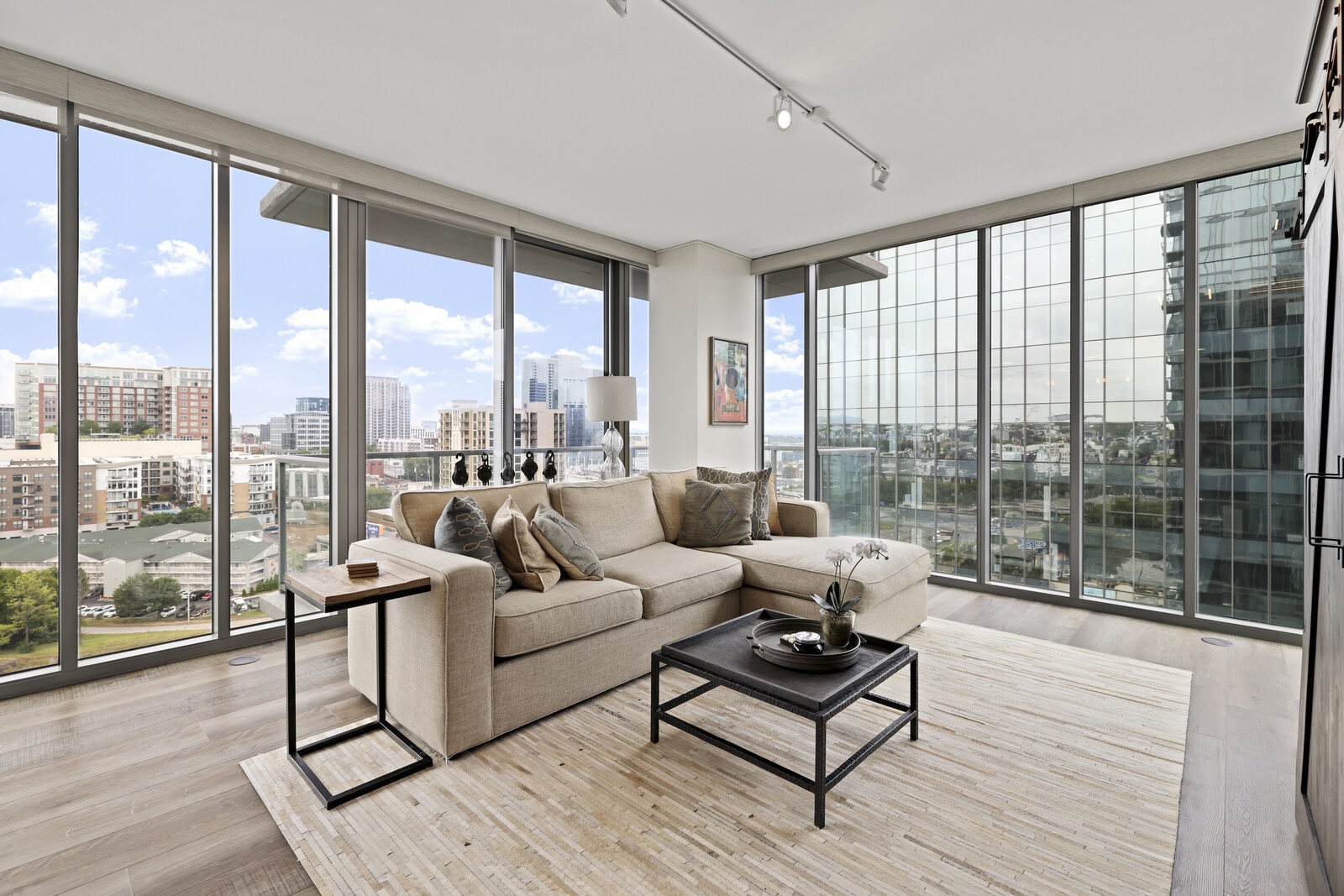 a living room with furniture and floor to ceiling windows