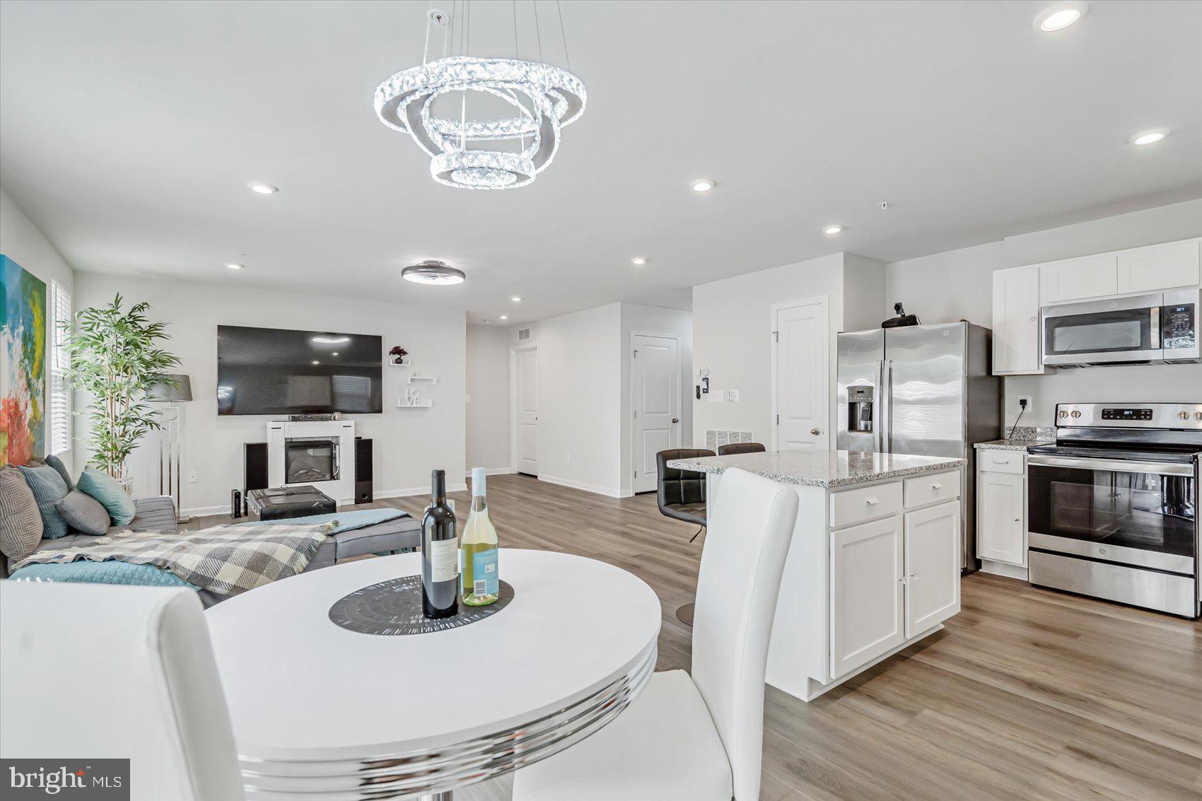 a kitchen with stainless steel appliances wooden floor dining table and chairs