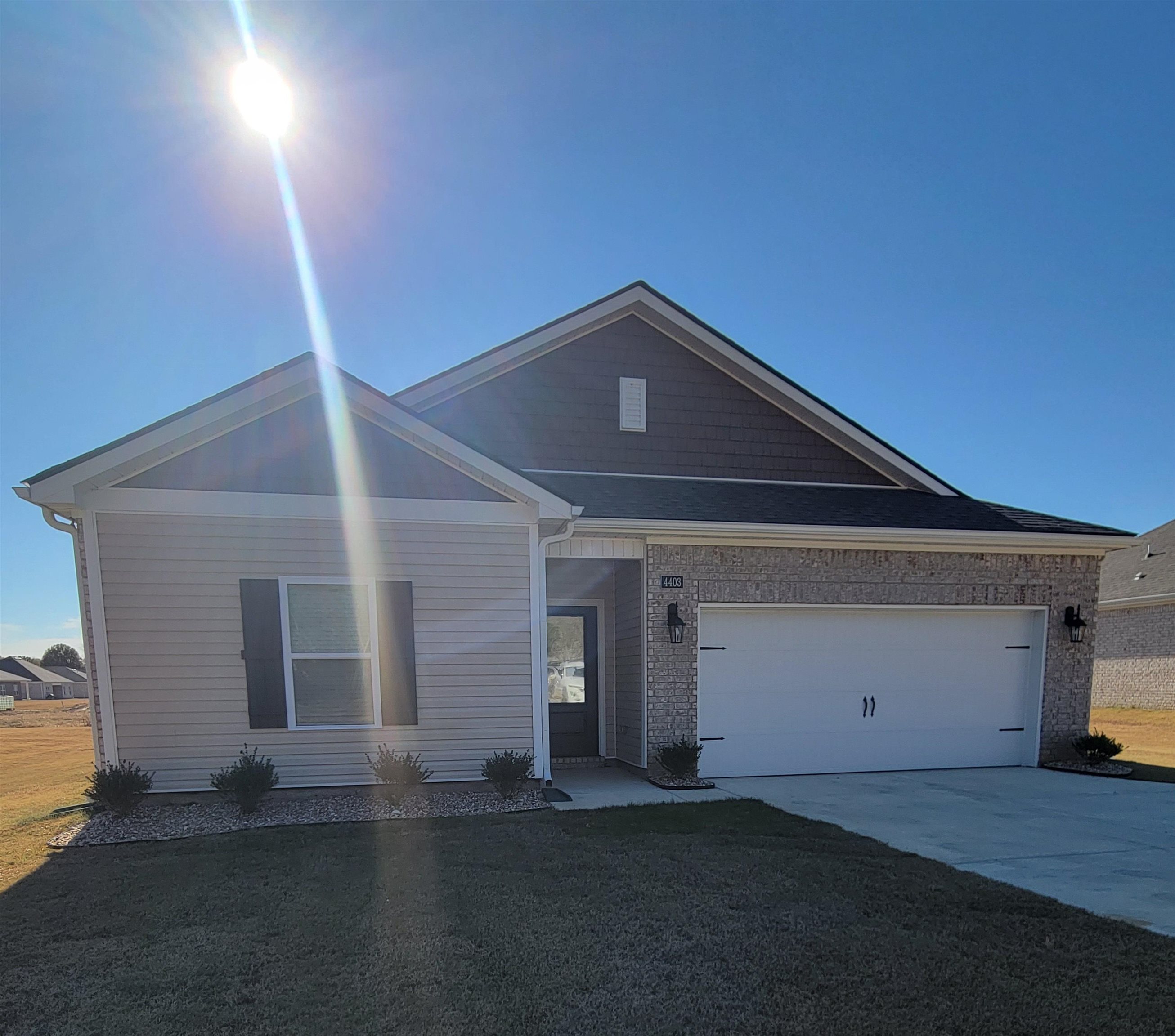 View of front facade featuring a front yard and a garage