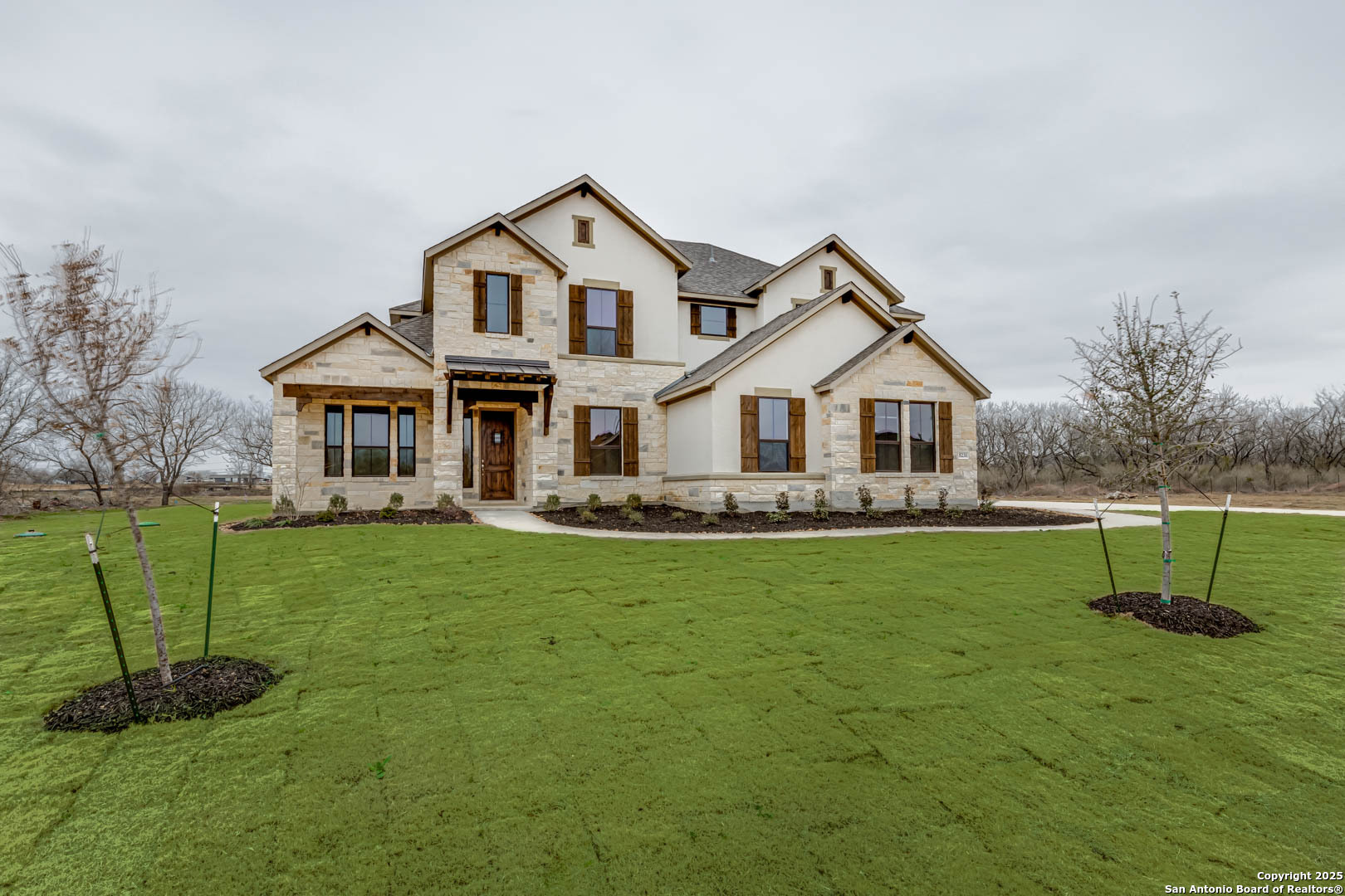 a front view of a house with a yard and trees