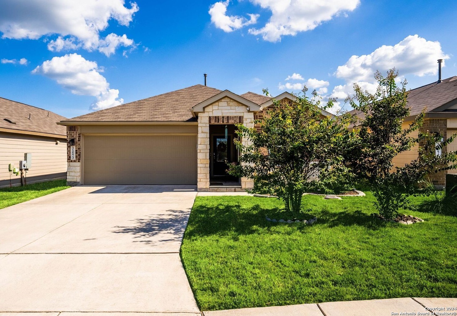 a front view of a house with a yard and garage