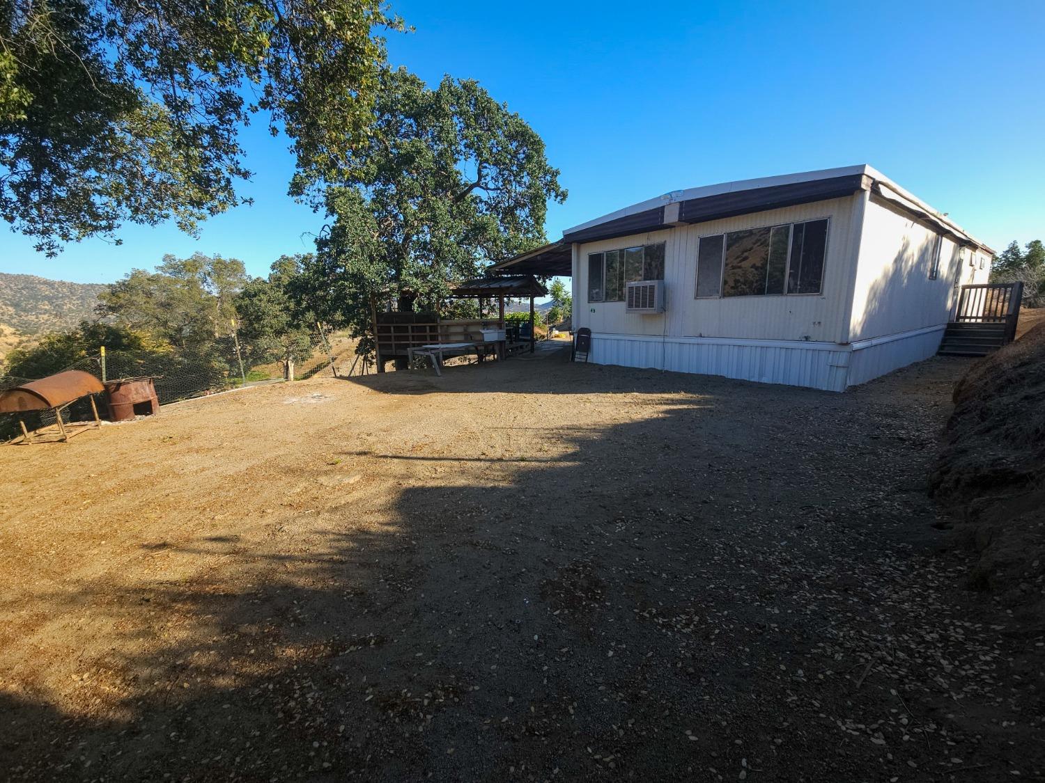 a view of a house with backyard and trees