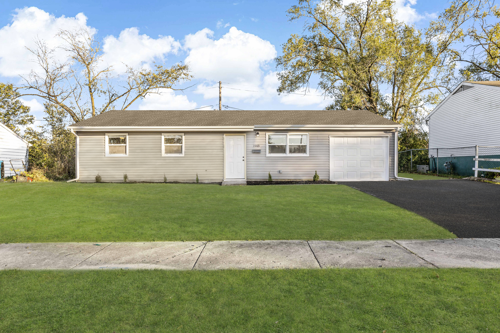 a front view of a house with a garden and yard