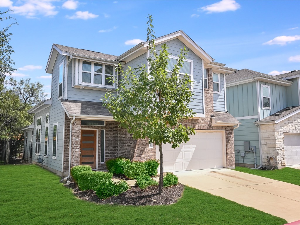 a front view of a house with a yard and trees