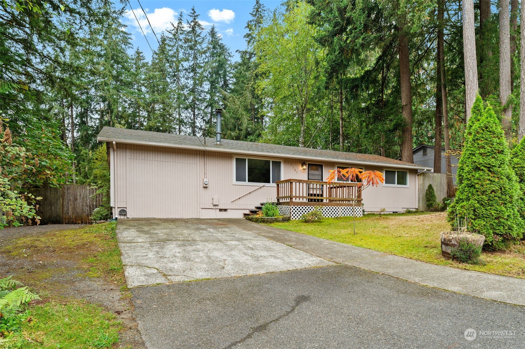 a front view of house with yard and trees in the background