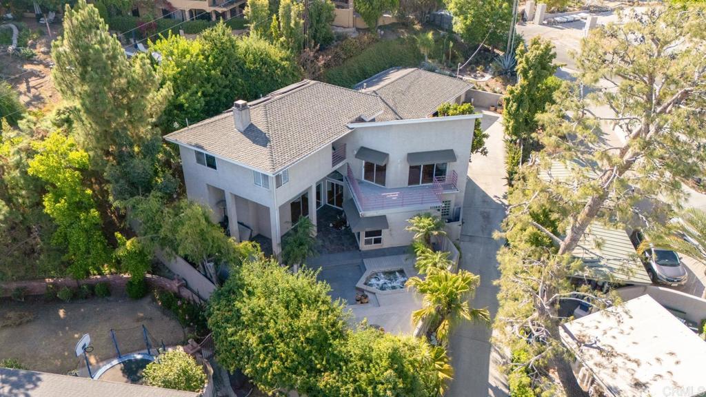 aerial view of a house with a yard and large trees