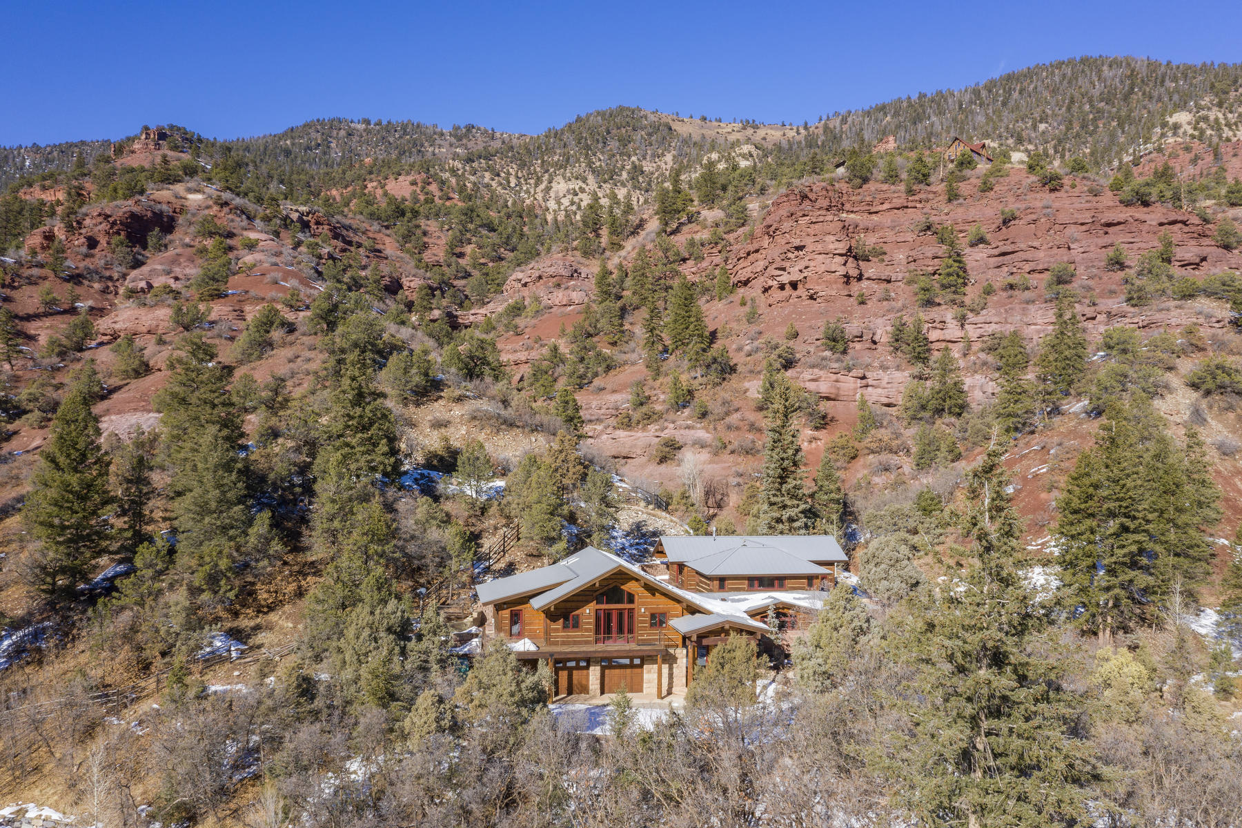 an aerial view of a house with a mountain