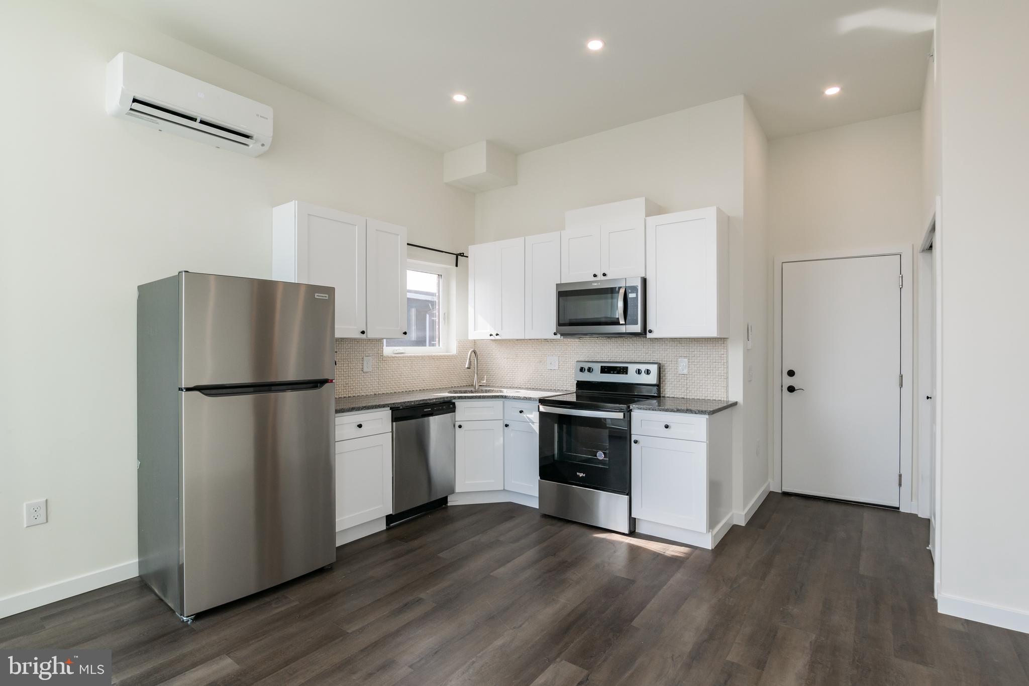 a kitchen with a refrigerator stove top oven and sink