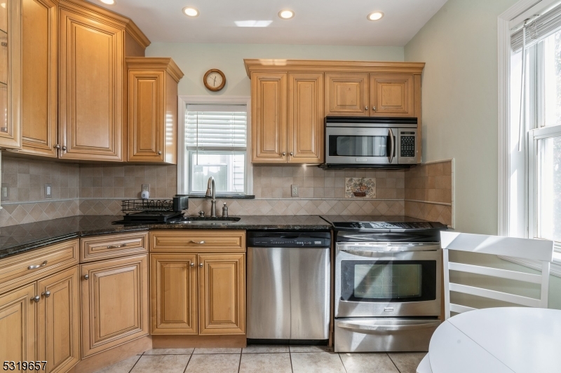 a kitchen with granite countertop a stove and a microwave