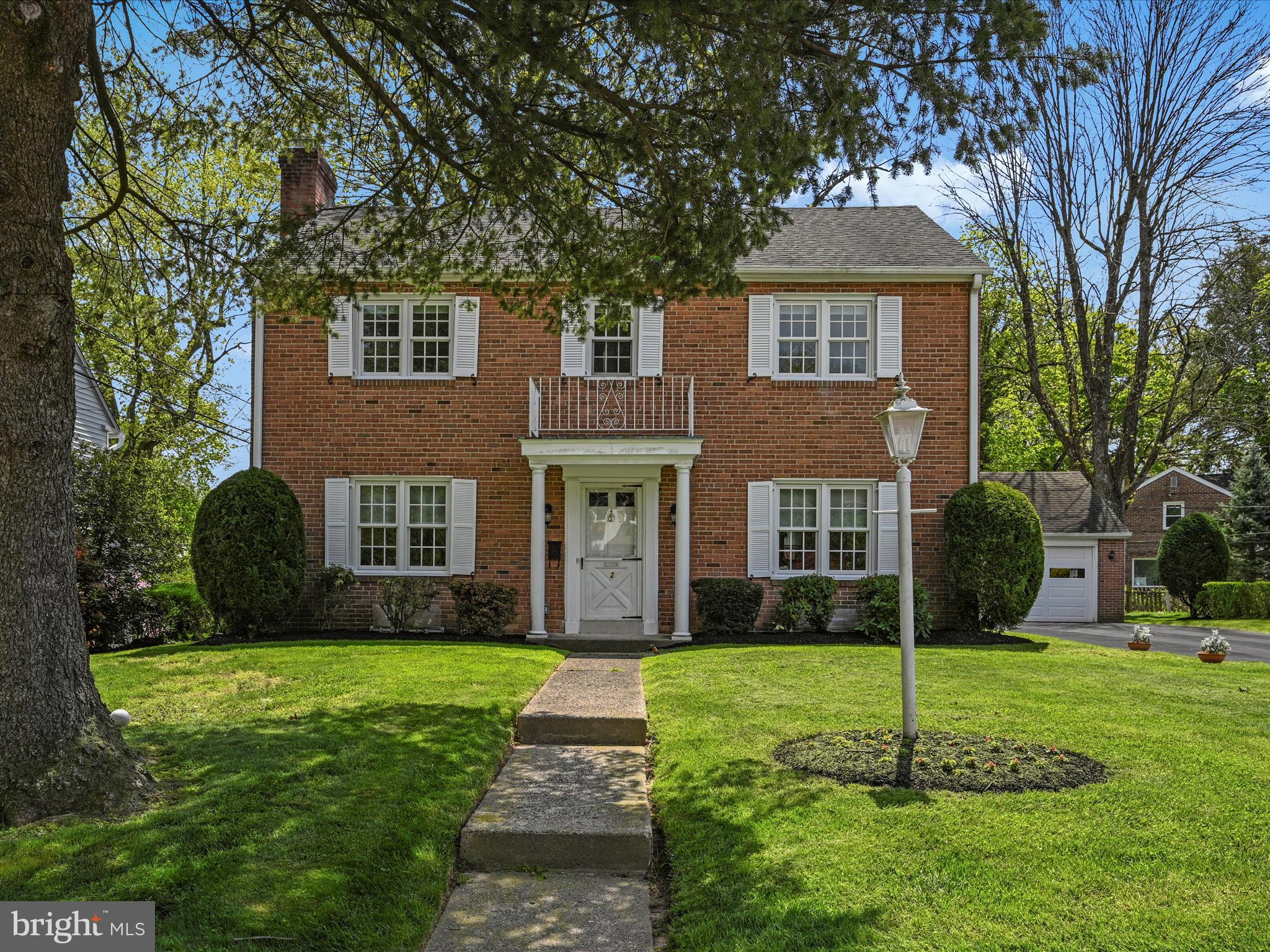 a front view of a house with a yard and trees