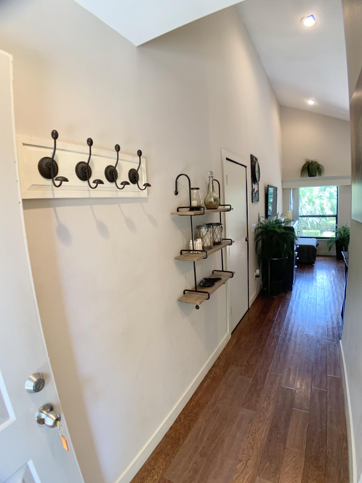 a view of a hallway with workspace and wooden floor