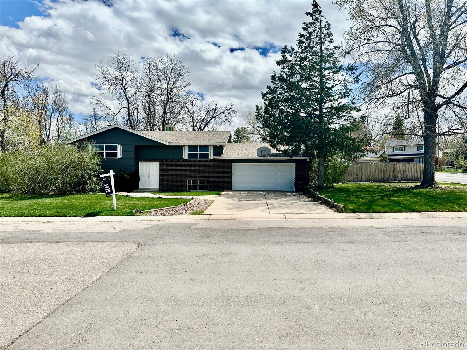 a front view of house with yard and trees in the background