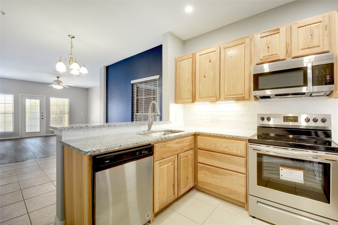 a kitchen with granite countertop a stove sink and microwave