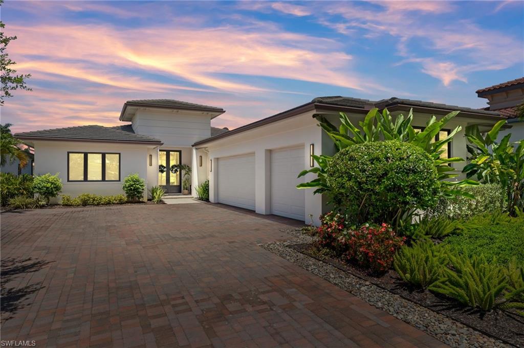 a very nice looking house with a big yard and potted plants