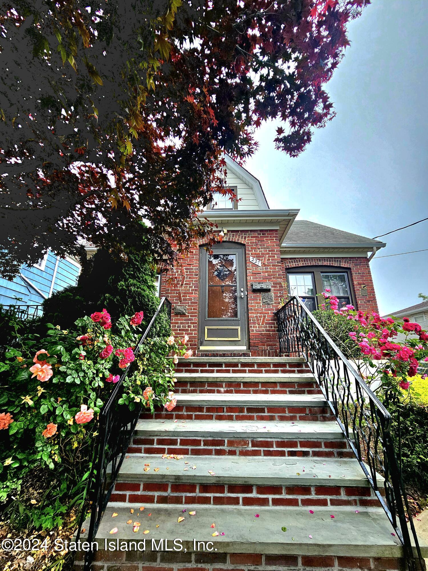 a view of a house with large windows and a flower garden