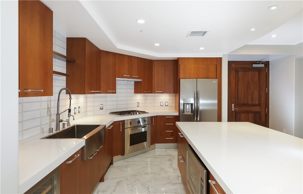 a large kitchen with stainless steel appliances granite countertop a sink and cabinets