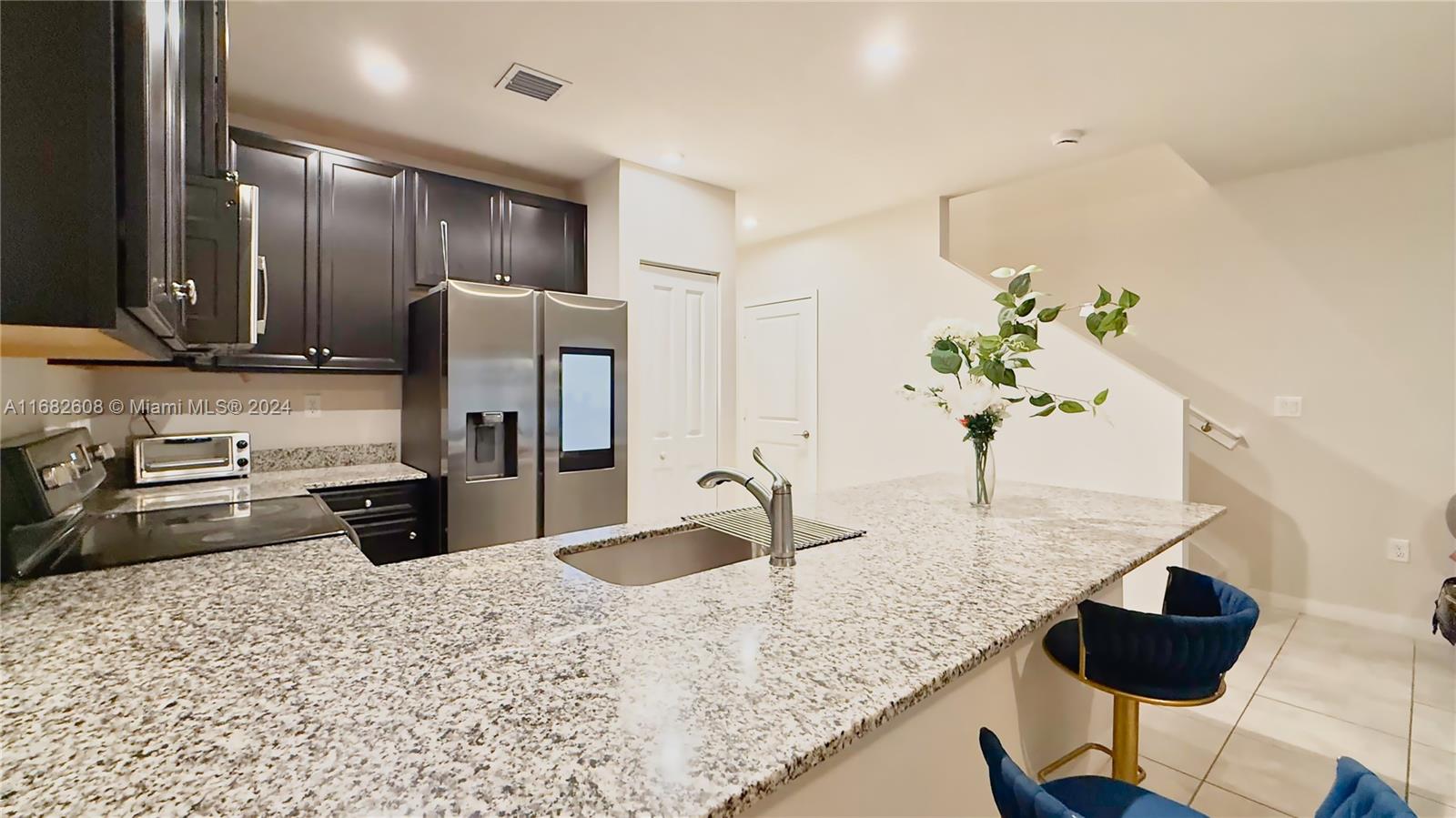 a kitchen with stainless steel appliances granite countertop sink refrigerator and stove