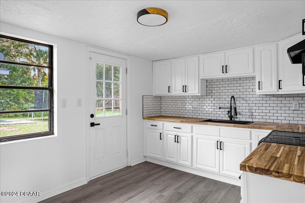 a kitchen with granite countertop a sink window and cabinets