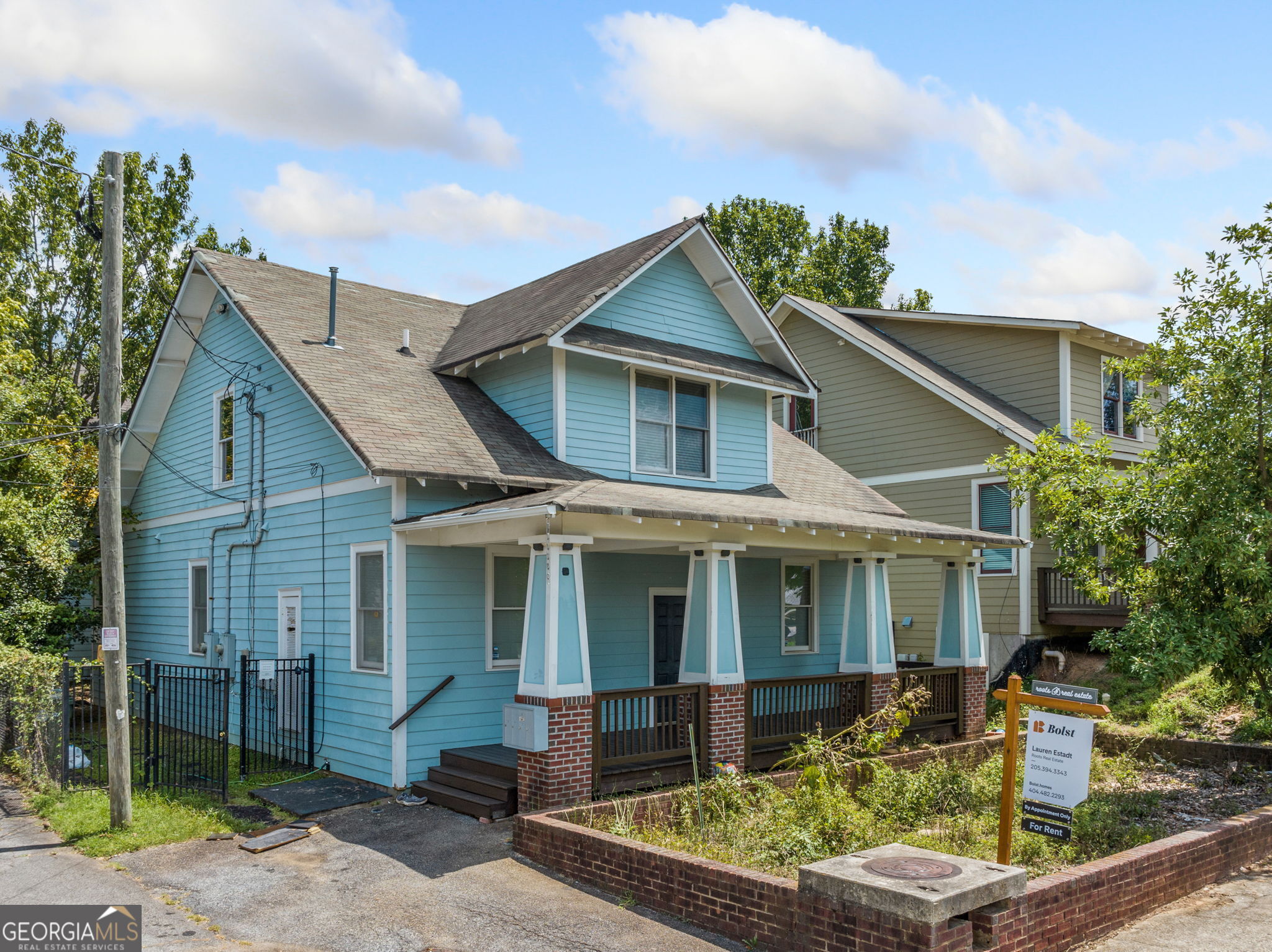 a front view of a house with a yard and potted plants