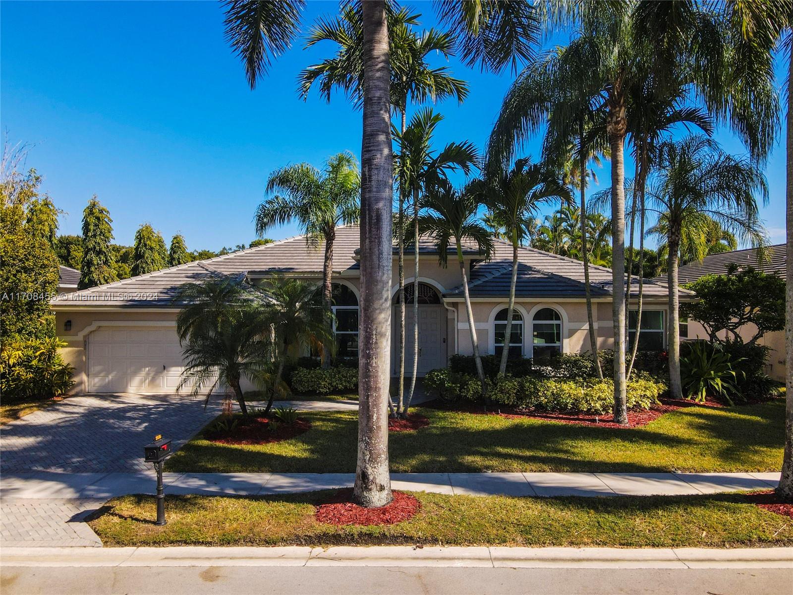 a view of a house with a yard and palm trees