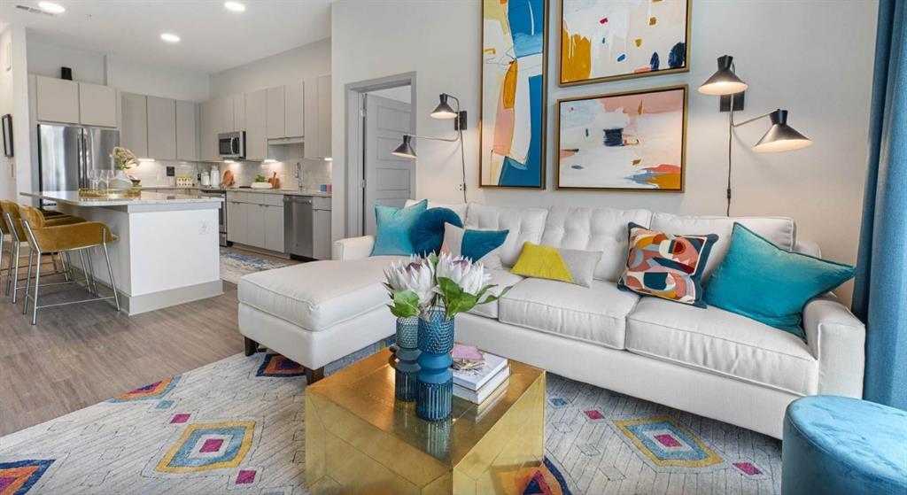 a living room with furniture and a dining area with kitchen view